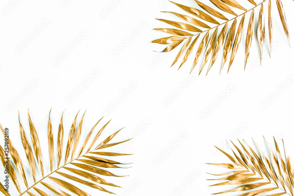 Gold tropical palm leaves on white background. Flat lay, top view minimal concept. Gold tropical palm leaves on white background. Flat lay, top view minimal concept.