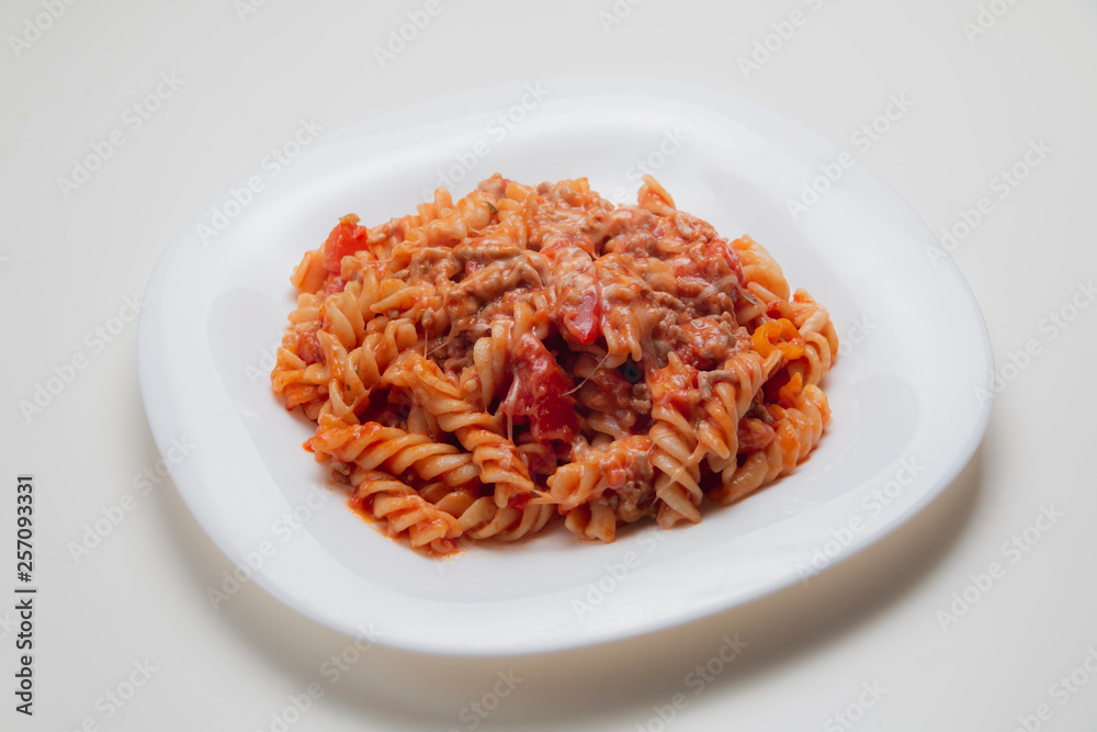 Cooked pasta in a white plate on white background Cooked pasta in a white plate on white background