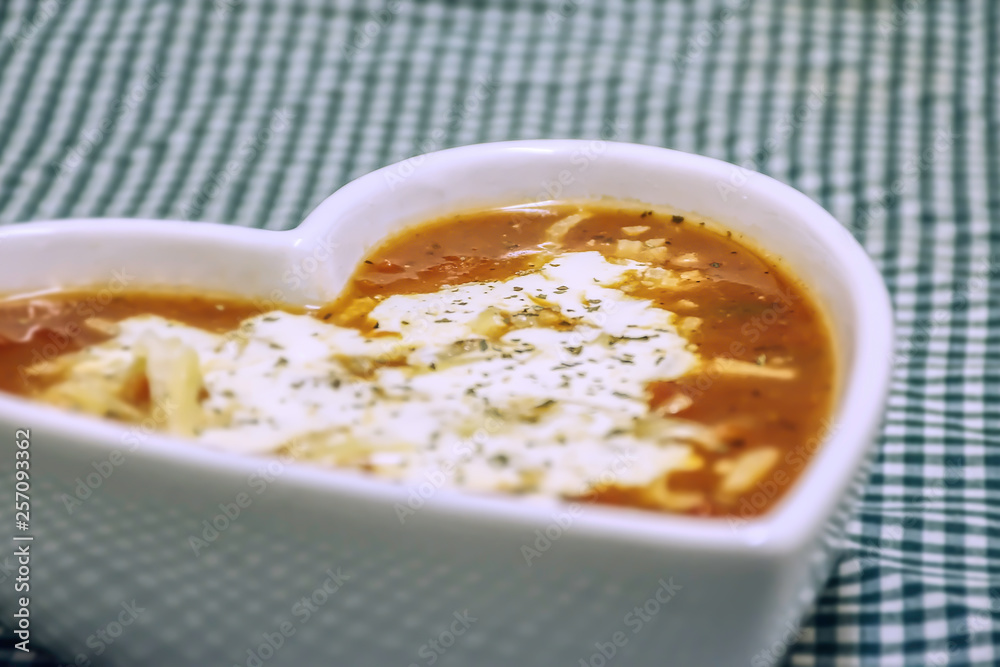 Tomato and cheese soup in heart shaped bowl. Tomato and cheese soup in heart shaped bowl.