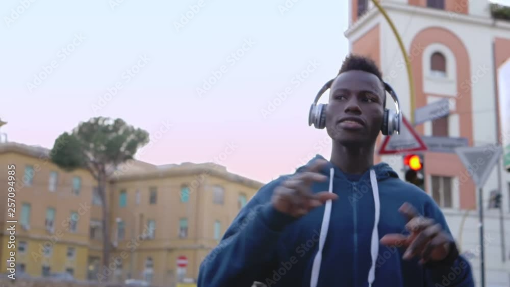Happy young black african guy dancing in the street listening to music Happy young black african guy dancing in the street listening to music