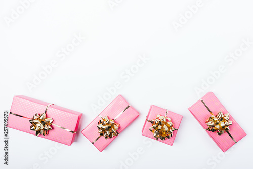 Flat lay arrangement of bright pink packaged gifts with golden © progressman