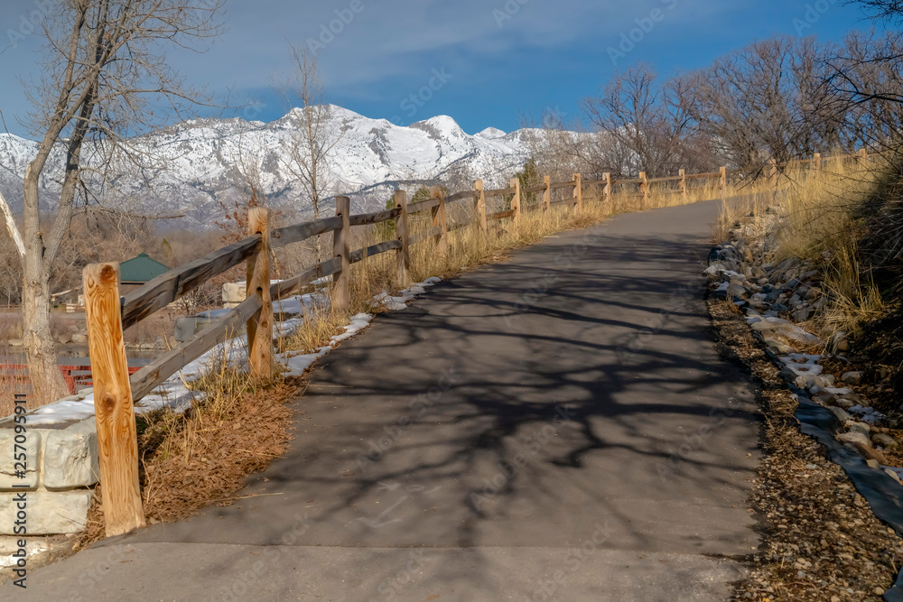 Road with wood fence overlooking mountain and sky Road with wood fence overlooking mountain and sky