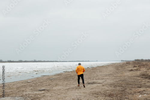 man's travels in a yellow sweater