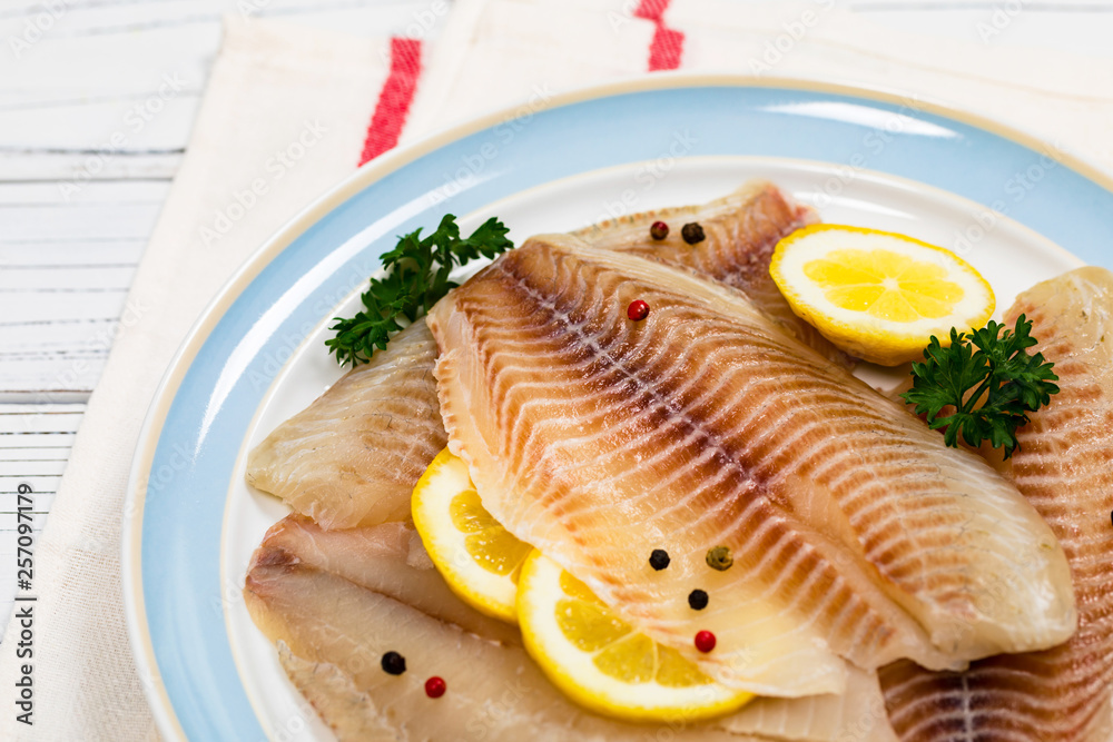 Whitefish Tilapia Fish Raw Fillet on White Wooden Background. Selective focus. Whitefish Tilapia Fish Raw Fillet on White Wooden Background. Selective focus.