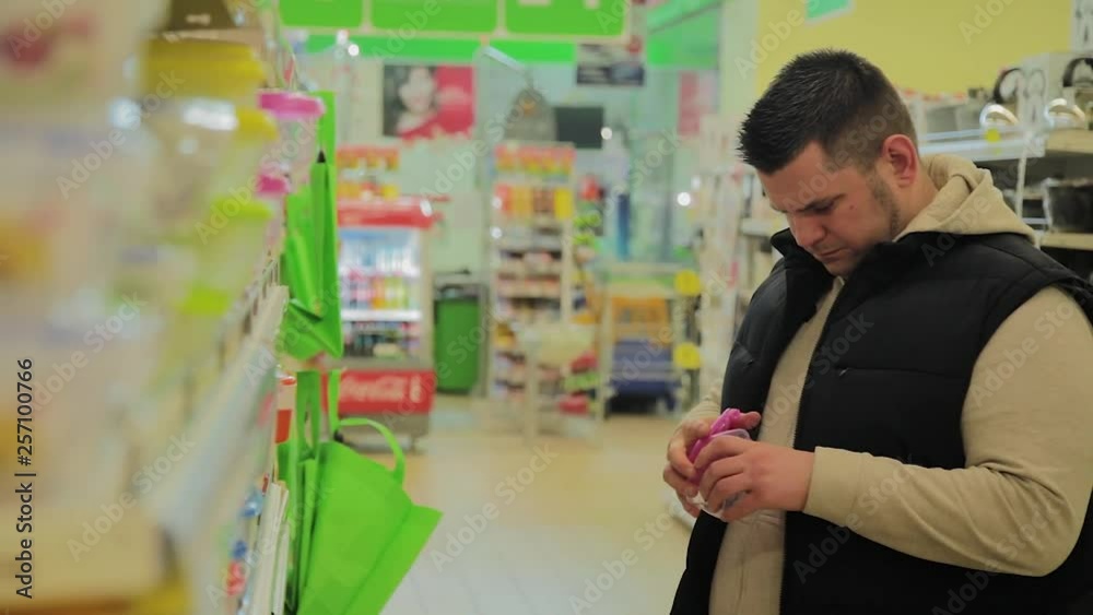 man chooses a container for food in the store. man chooses a container for food in the store.