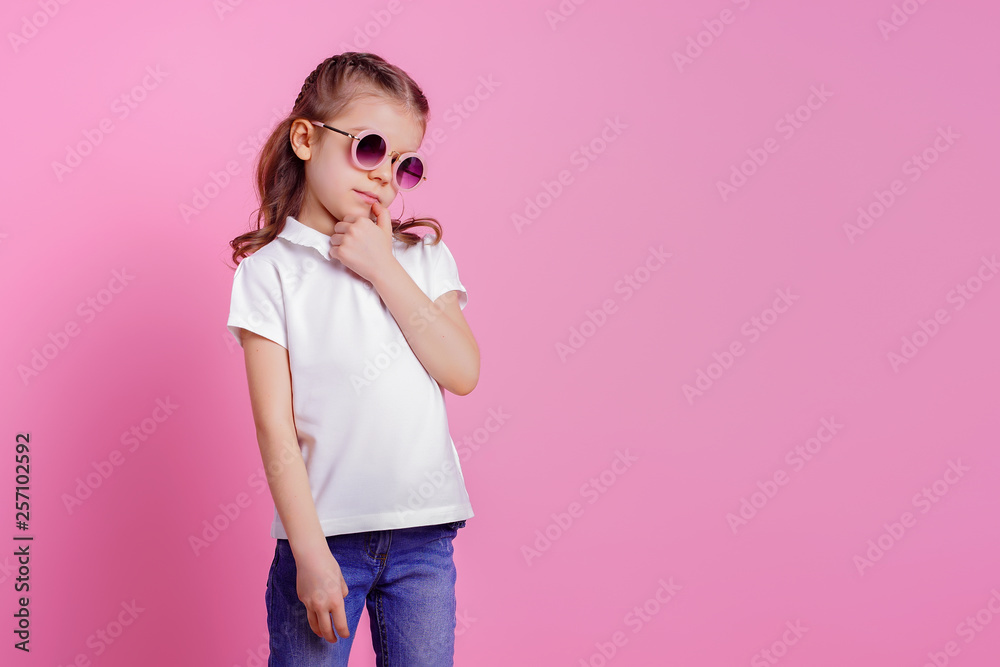 Portrait of beautiful smiling cute model in trendy round sunglasses. Casual 7 y.o. girl posing isolated on pink background. Portrait of beautiful smiling cute model in trendy round sunglasses. Casual 7 y.o. girl posing isolated on pink background.