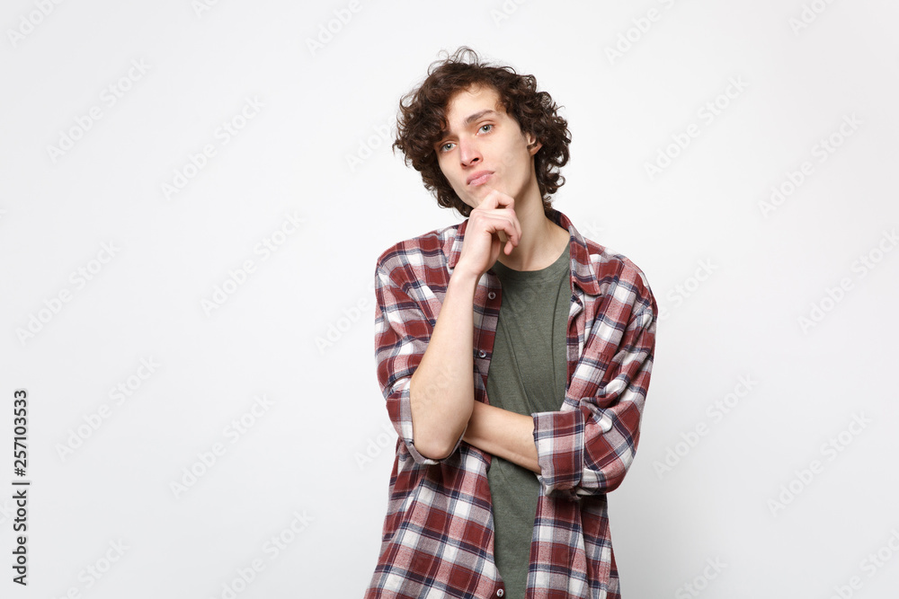 Portrait of pensive handsome young man in casual clothes looking camera put hand prop up on chin isolated on white background in studio. People sincere emotions, lifestyle concept. Mock up copy space. Portrait of pensive handsome young man in casual clothes looking camera put hand prop up on chin isolated on white background in studio. People sincere emotions, lifestyle concept. Mock up copy space.