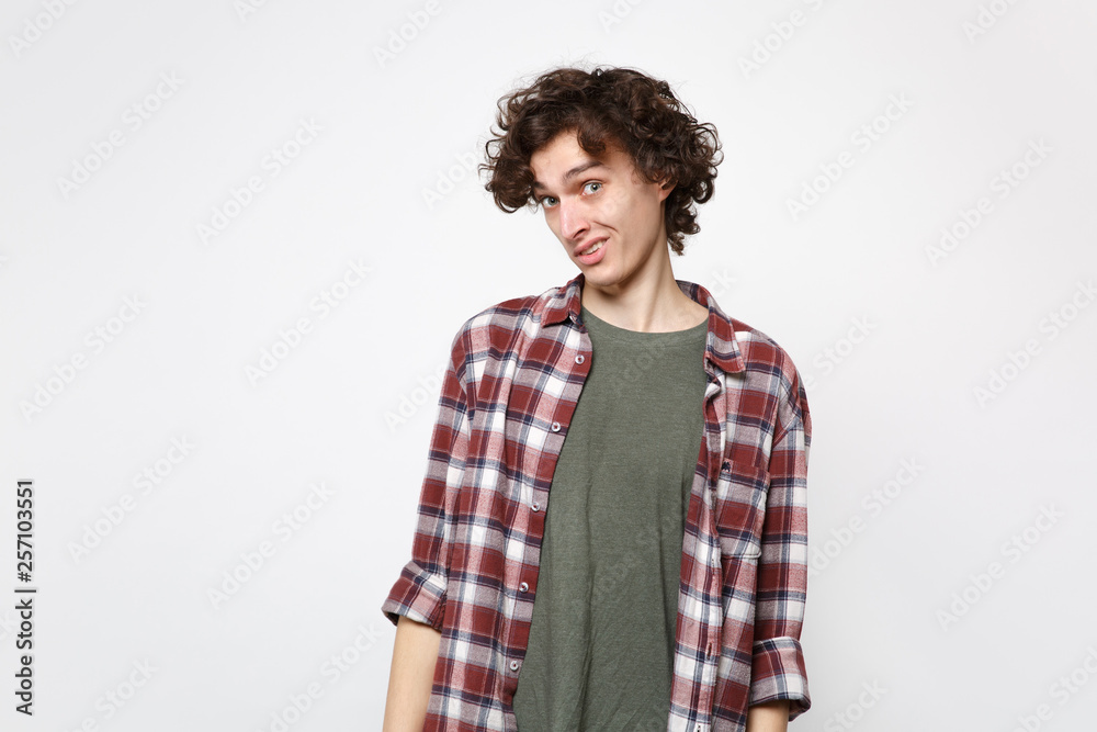 Portrait of perplexed bewildered young man in casual clothes standing and looking camera isolated on white wall background in studio. People sincere emotions, lifestyle concept. Mock up copy space. Portrait of perplexed bewildered young man in casual clothes standing and looking camera isolated on white wall background in studio. People sincere emotions, lifestyle concept. Mock up copy space.
