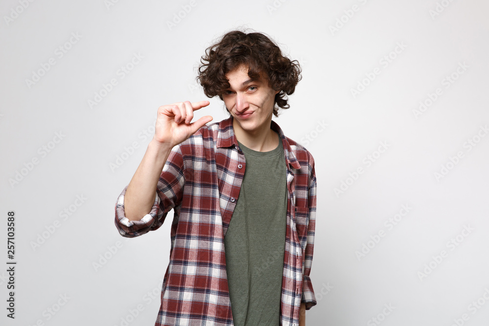 Portrait of puzzled smirked young man in casual clothes gesturing demonstrating size with workspace isolated on white wall background. People sincere emotions, lifestyle concept. Mock up copy space. Portrait of puzzled smirked young man in casual clothes gesturing demonstrating size with workspace isolated on white wall background. People sincere emotions, lifestyle concept. Mock up copy space.