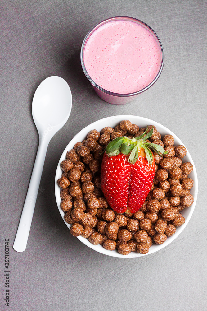DESAYUNO CON BOL DE CEREALES DE CHOCOLATE CON FRESA Y BATIDO CON CUCHARA BLANCA DESAYUNO CON BOL DE CEREALES DE CHOCOLATE CON FRESA Y BATIDO CON CUCHARA BLANCA