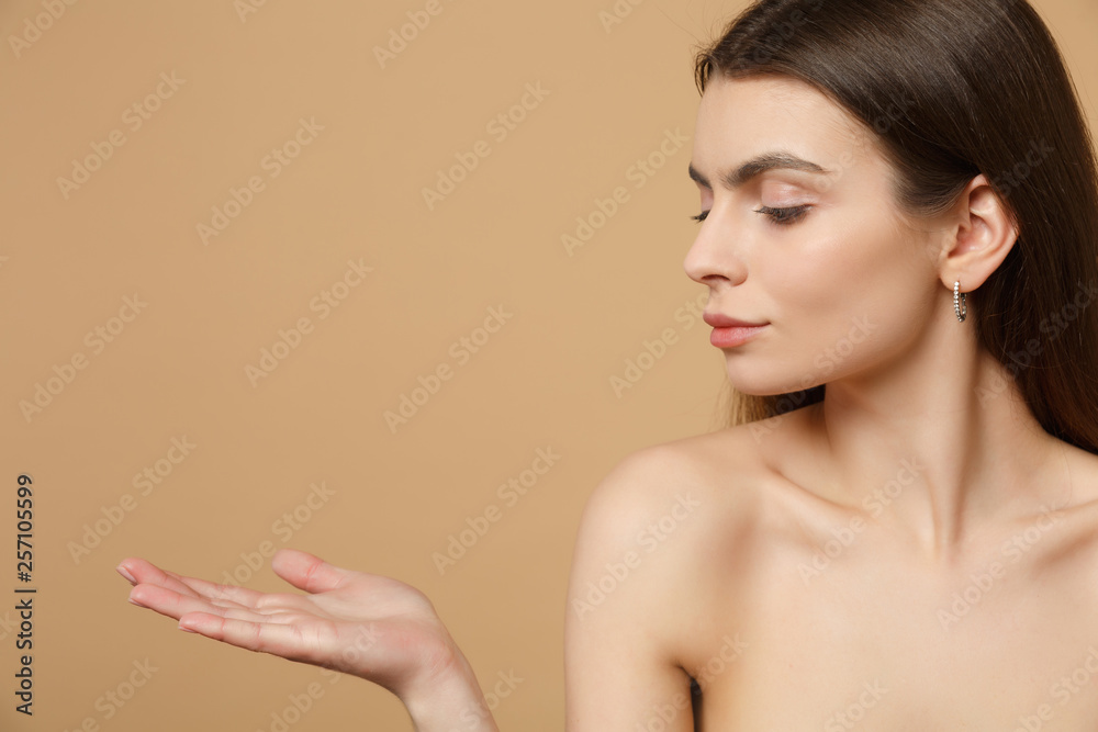 Close up brunette half naked woman 20s with perfect skin, nude make up isolated on beige pastel wall background, studio portrait. Skin care healthcare cosmetic procedures concept. Mock up copy space. Close up brunette half naked woman 20s with perfect skin, nude make up isolated on beige pastel wall background, studio portrait. Skin care healthcare cosmetic procedures concept. Mock up copy space.
