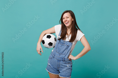 Laughing young girl football fan cheer up support favorite team with soccer ball isolated on blue turquoise wall background. People emotions sport family leisure lifestyle concept. Mock up copy space. © ViDi Studio