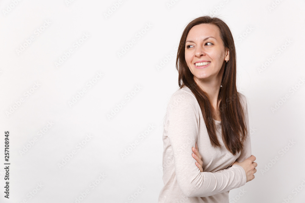 Portrait of cheerful joyful young woman in light clothes looking aside holding hands folded isolated on white wall background in studio. People sincere emotions, lifestyle concept. Mock up copy space. Portrait of cheerful joyful young woman in light clothes looking aside holding hands folded isolated on white wall background in studio. People sincere emotions, lifestyle concept. Mock up copy space.