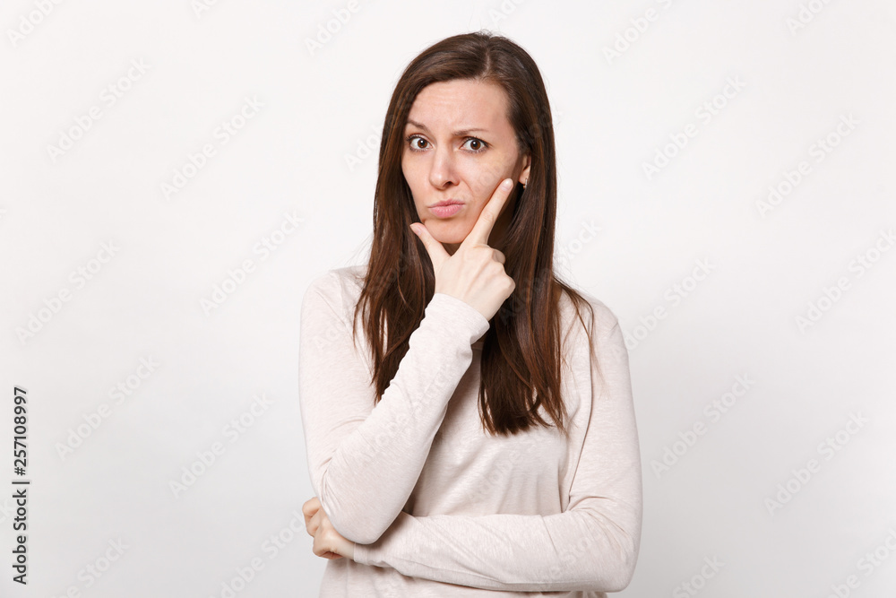 Portrait of pensive puzzled young woman in light clothes looking camera put hand prop up on chin isolated on white background in studio. People sincere emotions, lifestyle concept. Mock up copy space. Portrait of pensive puzzled young woman in light clothes looking camera put hand prop up on chin isolated on white background in studio. People sincere emotions, lifestyle concept. Mock up copy space.