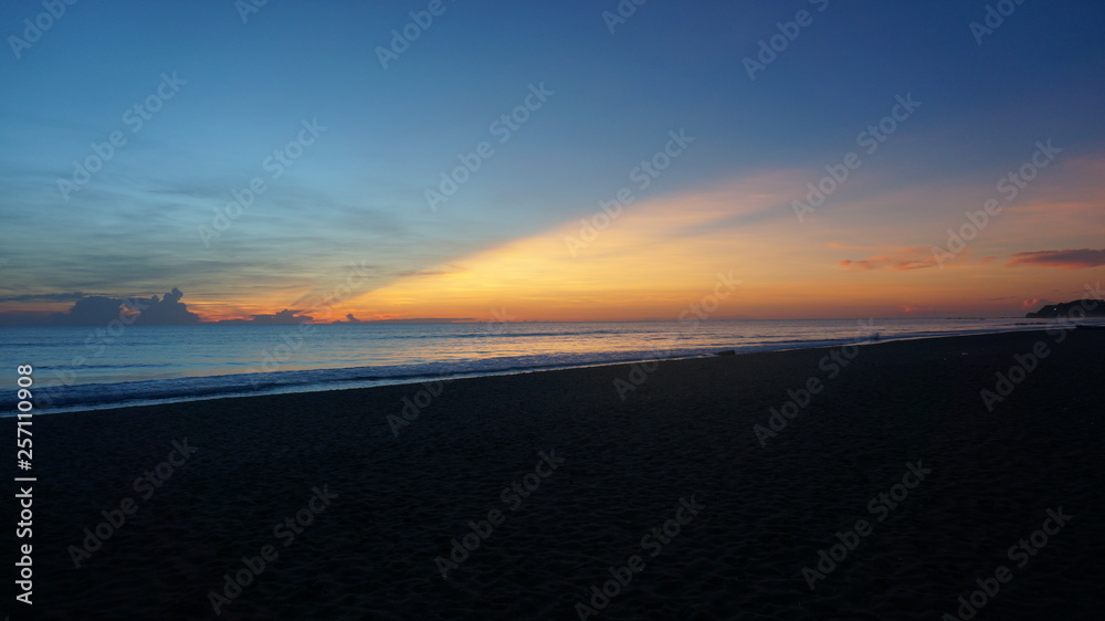 Sunrise with warm colors, blue and purple litghts reflecting in the waves Sunrise with warm colors, blue and purple litghts reflecting in the waves
