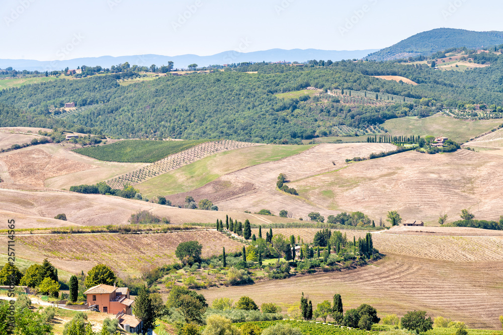 Val D'Orcia countryside aerial high angle view in Montepulciano, Tuscany, Italy with rolling plowed brown hills with farm landscape picturesque meadow fields