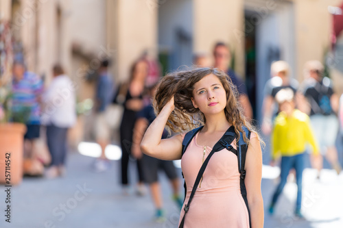 Montepulciano, Italy narrow alley street in small town village in Tuscany with young woman tourist sightseeing touching flipping hair on summer day © Andriy Blokhin