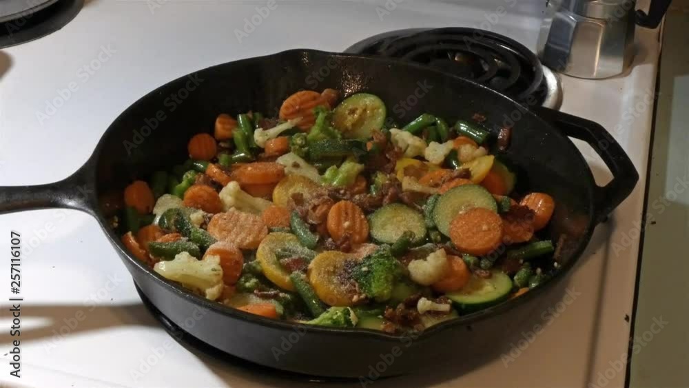 seasoning chopped vegies in a skillet