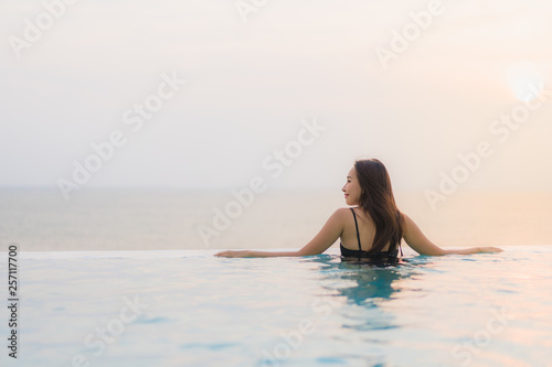 Portrait beautiful young asian woman happy smile relax around swimming pool in hotel resort © siraphol