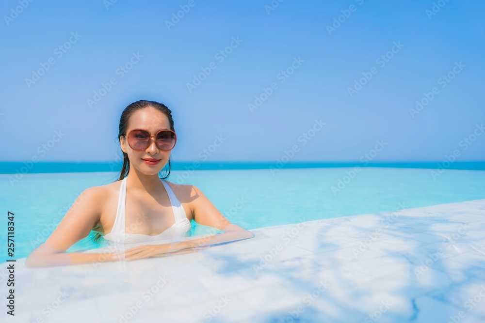 Portrait beautiful young asian woman happy smile relax in swimming pool for travel vacation