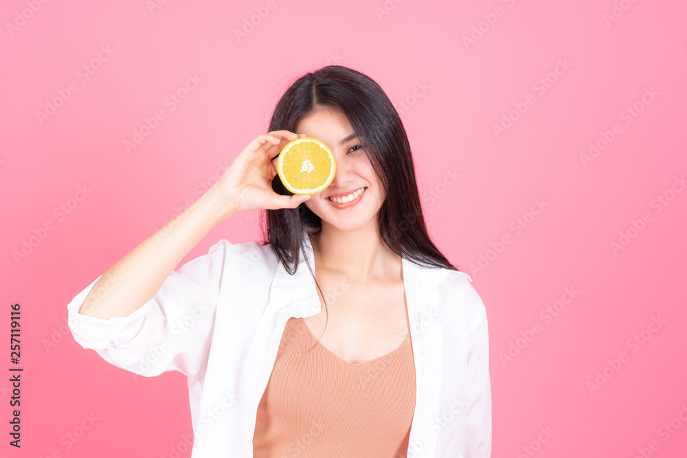  beauty woman Asian cute girl feel happy holdind orange fruit for good health  on pink background - lifestyle beauty woman