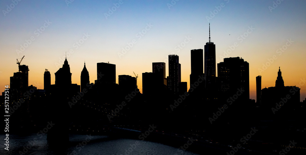 New York City skyline building silhouettes at dusk with color twilight sky above Manhattan