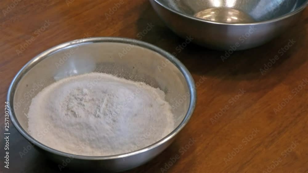 adding measured powder into a bowl adding measured powder into a bowl