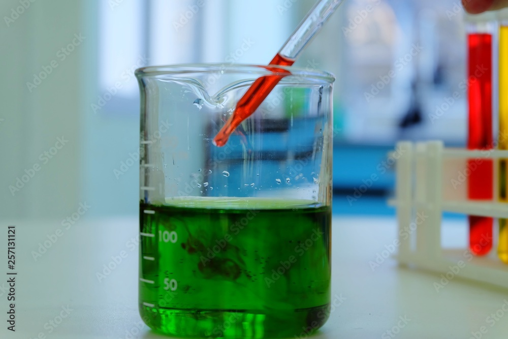 Pipette dropping a sample into a test tube, -close up - image Pipette dropping a sample into a test tube, -close up - image