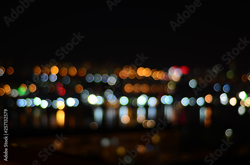 Blurred night city lights reflect in water © Tatiana Sidorova