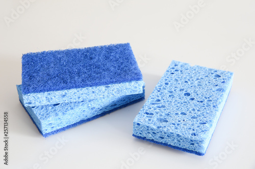 Close up of blue kitchen sponges in a white background