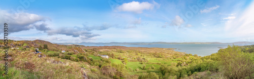 Two tourists sitting and looking at the panoramic landscape in Beara Peninsula