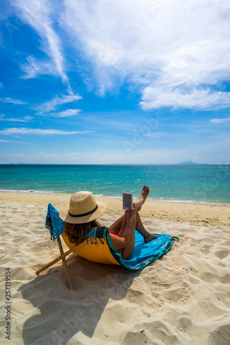 Fototapeta Naklejka Na Ścianę i Meble -  Woman enjoying her holidays on a transat at the tropical beach