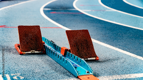 Athletics starting blocks on race blue track