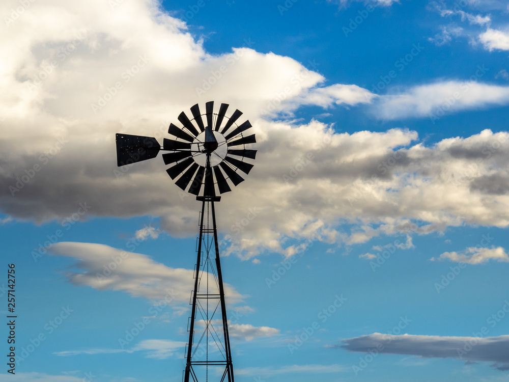 Windmill in Silhouette on a Blue and Cloudy Sky