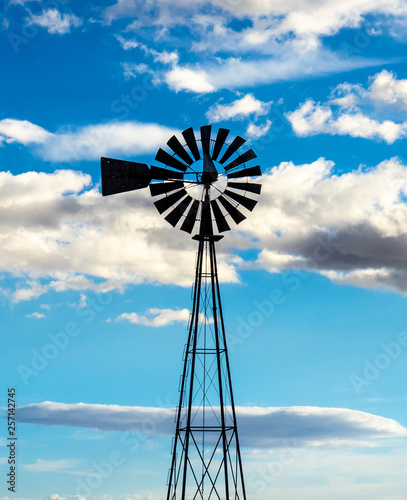 Windmill in Silhouette on a Blue and Cloudy Sky 