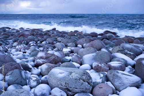 Stones on the coast of the Barents Sea in February twilight. Teriberka, Russia