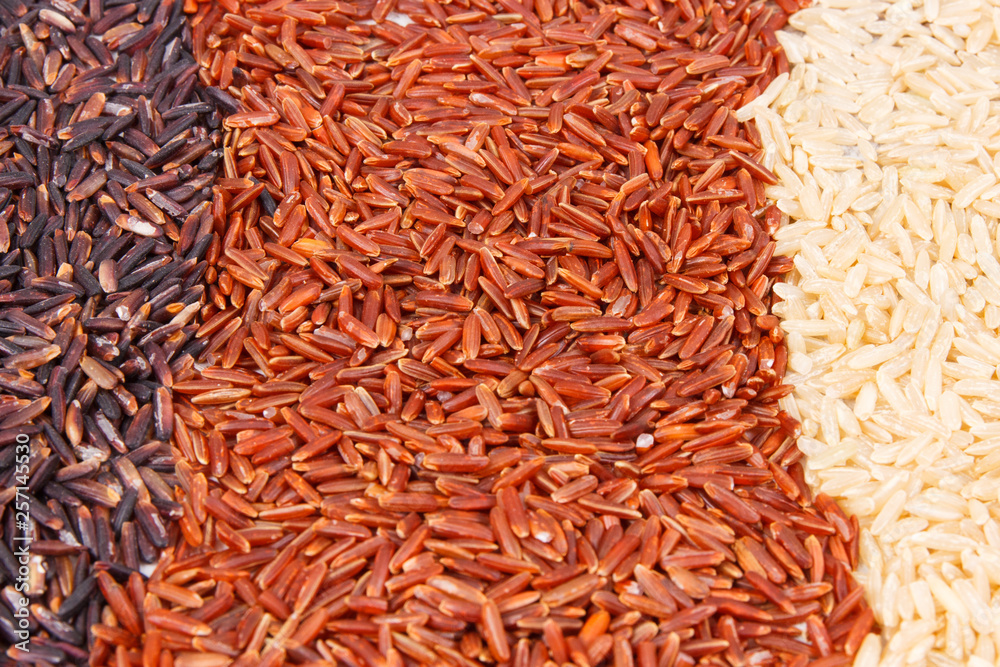 Heap of brown, red and black rice as background, healthy nutrition concept Heap of brown, red and black rice as background, healthy nutrition concept