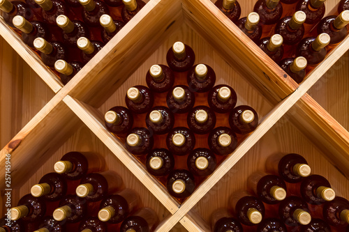 stacked bottles of grape wine in a wine cellar photo