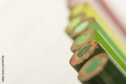 various tones of green color pencils Close up on white background
