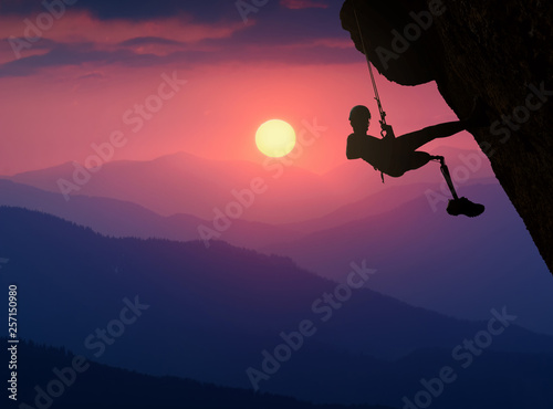 Climber with prothesis on a cliff