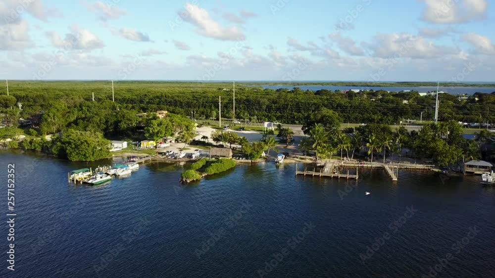AERIAL: from the ocean, looking towards a mini beach, dock, and the highway that runs straight through Key Largo. AERIAL: from the ocean, looking towards a mini beach, dock, and the highway that runs straight through Key Largo.