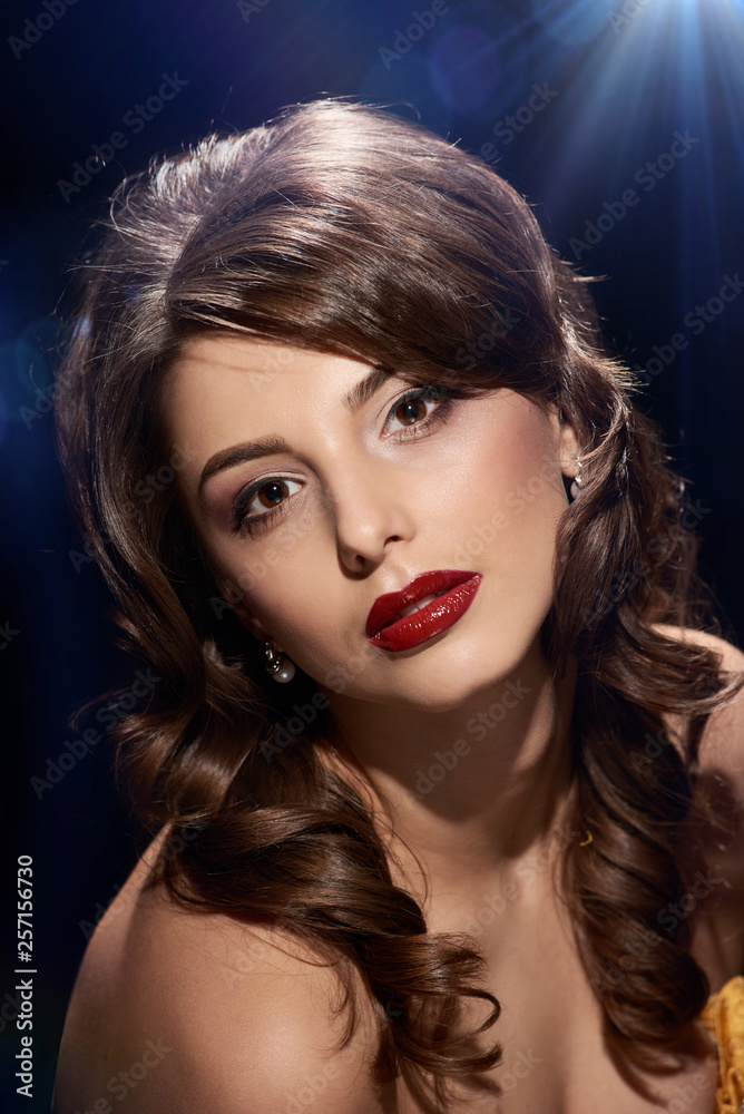 Fototapeta premium Luxurious portrait of young beautiful brunette with bright make-up, background with different highlights