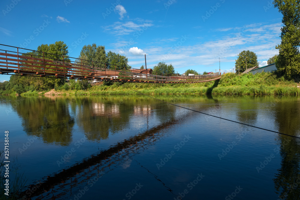 Suspension bridge over the river Msta on a summer day. City Borovichi, Russia