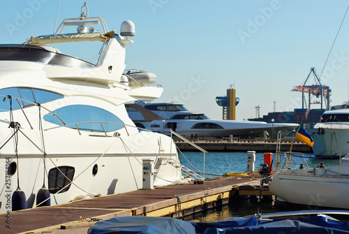White yacht on the pier. Elegant yachts on the background of the blue sky.