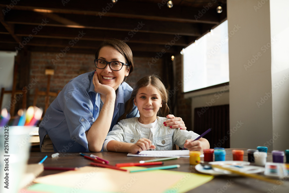 Portrait of happy young woman posing with daughter while painting together at home, copy space Portrait of happy young woman posing with daughter while painting together at home, copy space