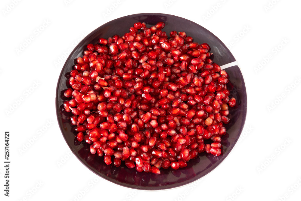 red ripe pomegranate seeds on a brown plate close-up. pomegranate fruit. healthy diet. red ripe pomegranate seeds on a brown plate close-up. pomegranate fruit. healthy diet.