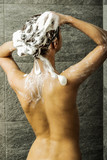 Young woman washing hair in shower. Everyday routine caring body.