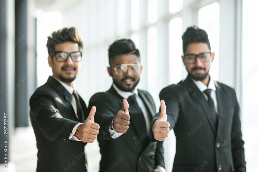 Happy successful three indian businessmen with thumbs up gesture at office Happy successful three indian businessmen with thumbs up gesture at office