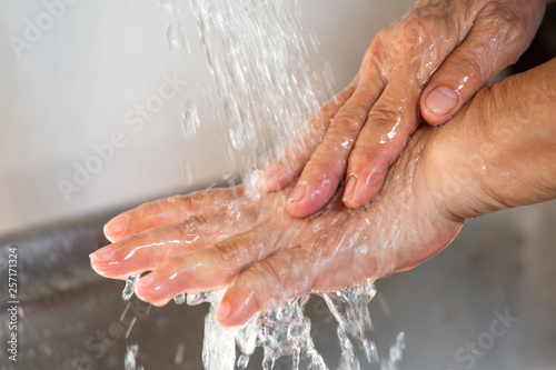 Senior woman washing her hands, Flowing and Splashing water, Close up & Macro shot, Selective focus, Healthcare concept