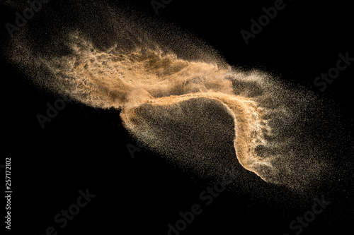 Golden dry river sand explosion isolated on white background. Abstract sand splashing. photo